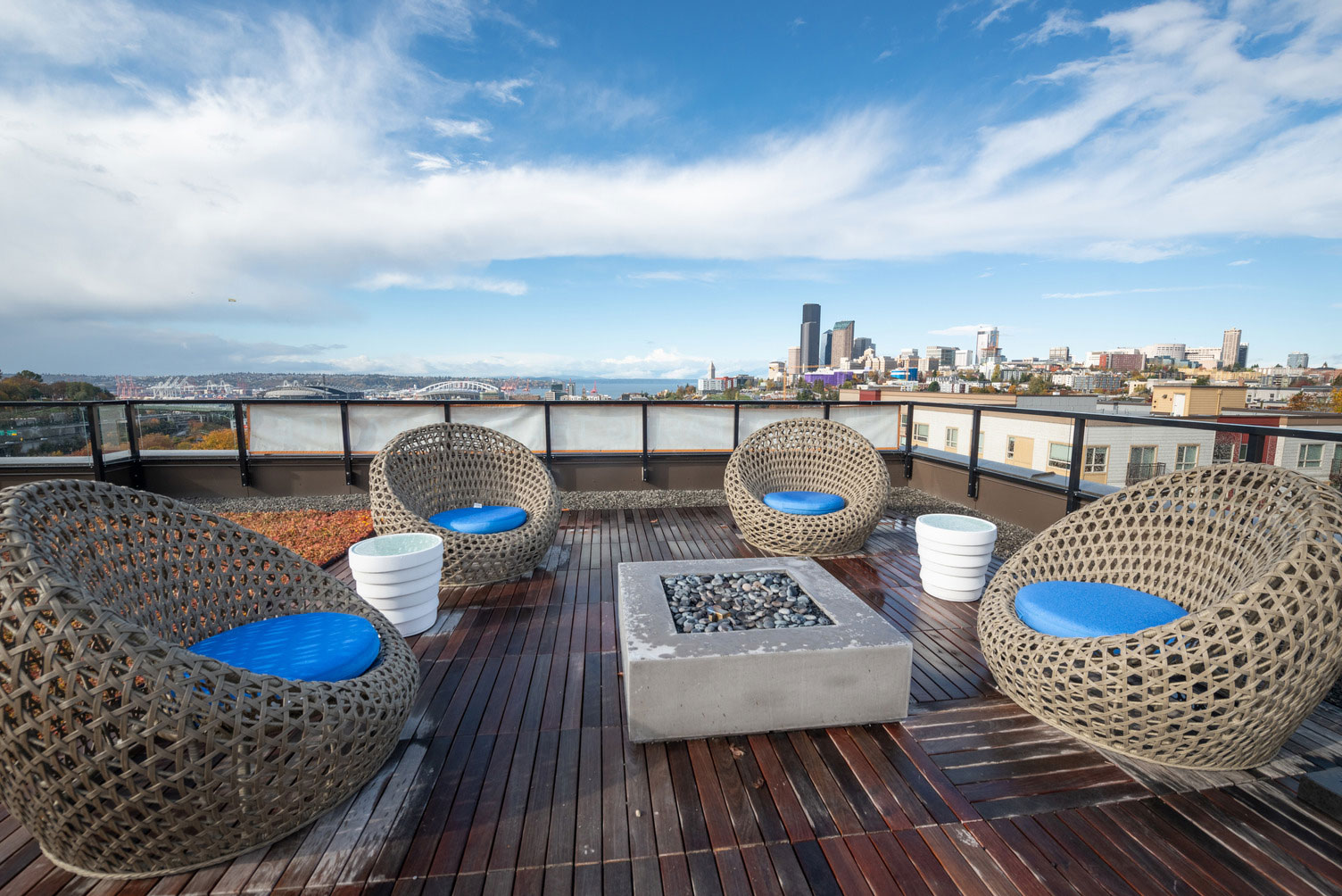 Rooftop overlooking city with chair seating around a firepit