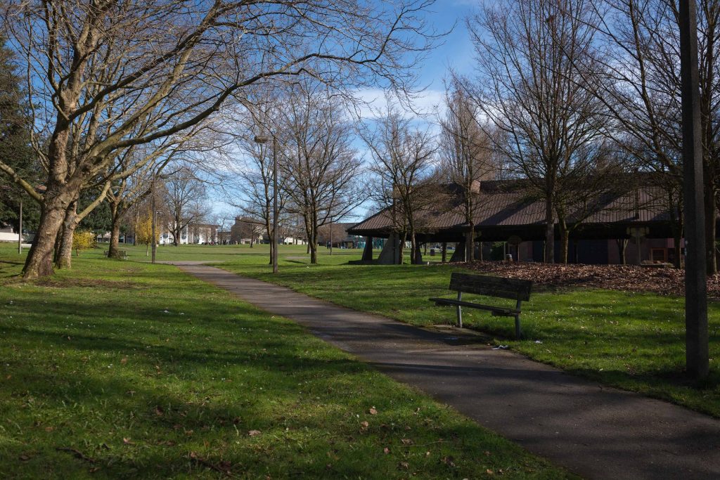 Outdoor park area with jogging path, trees, and benches for resting