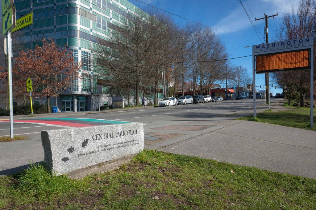 Street side view of sign for Central Park Trail and crosswalk across street