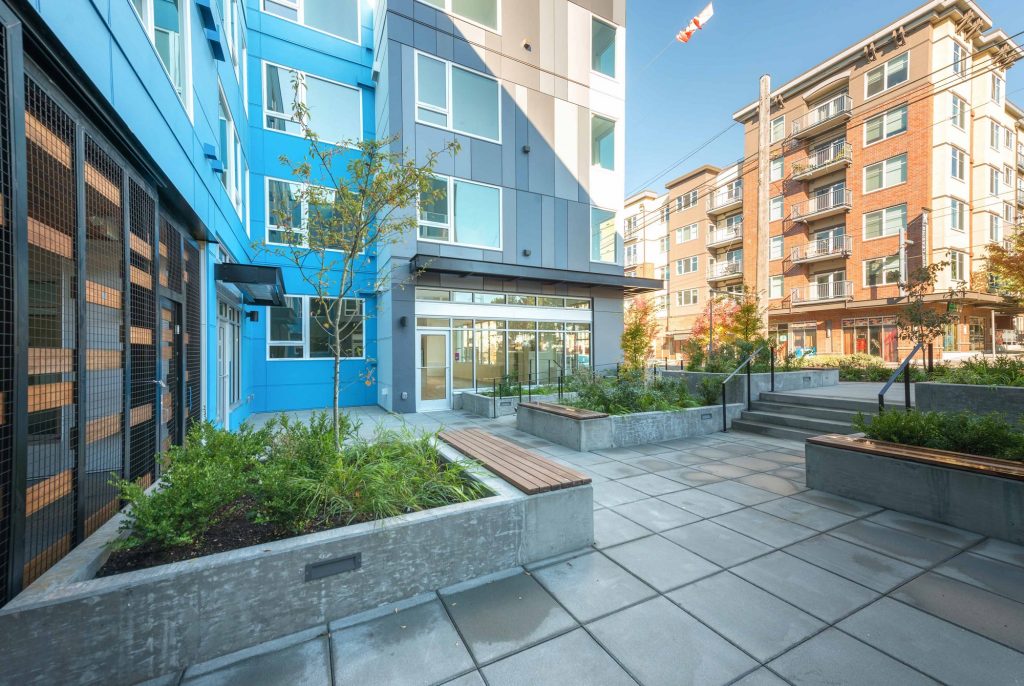 Apartment exterior with garden landscaping and entrance to leasing center