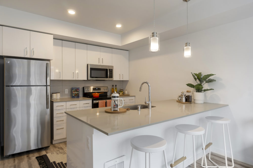 Bell Jackson Street kitchen with white cabinetry, stainless steel refrigerator and large countertop